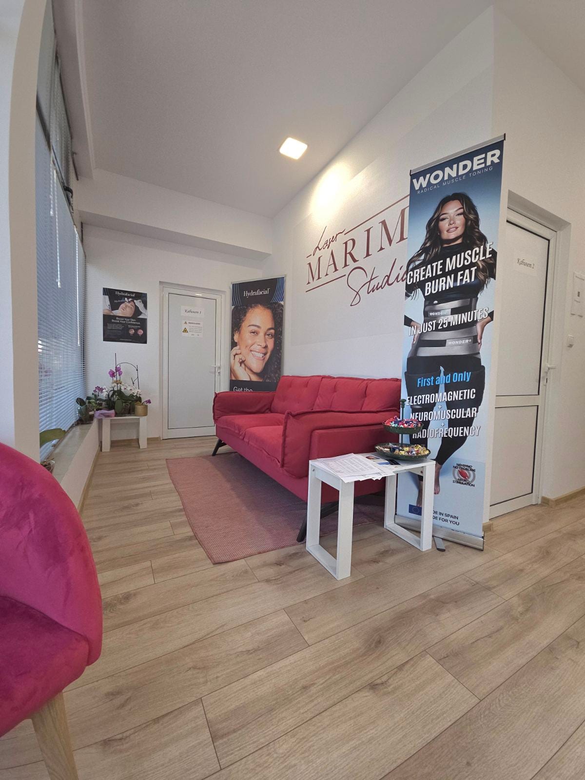 Кабинет за HydraFacial процедури — бяло козметично кресло пред брандирана стена